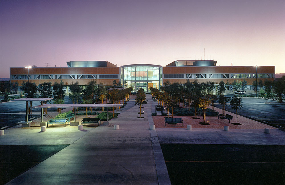 Image 1. Front view of 3-story concrete, glass and steel building with a plaza in the foreground.