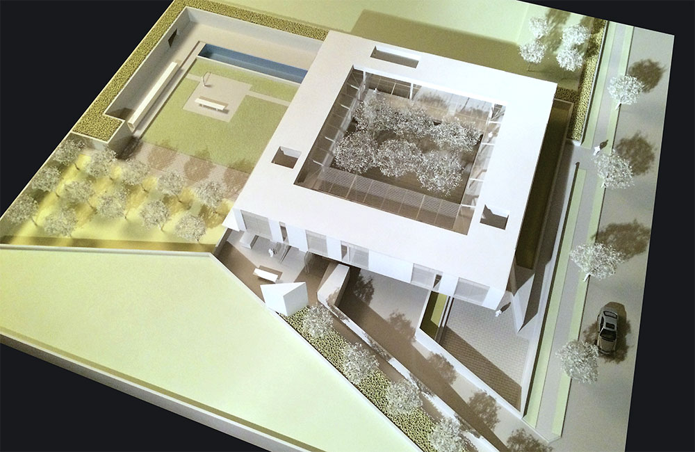 Image 5. Aerial view of model showing a 2-story modern square shaped residence with a central courtyard.