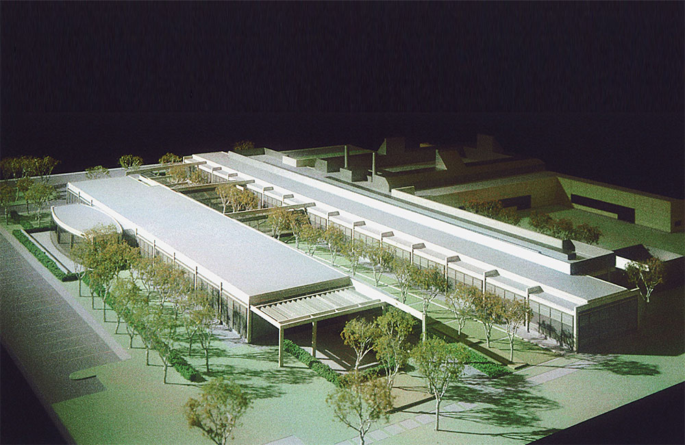 Image 2. Aerial view showing model of 2 modern 1-story structures with an outdoor lawn area populated with trees located between them.