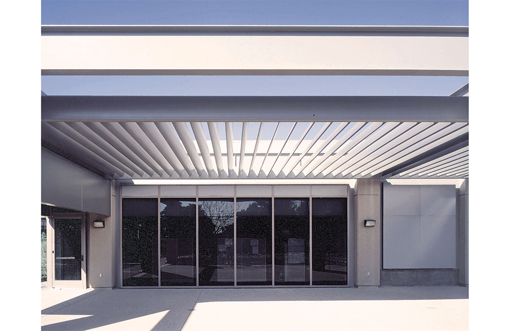 Image 4. Side view of building showing full-height storefront system and a slatted canopy above.