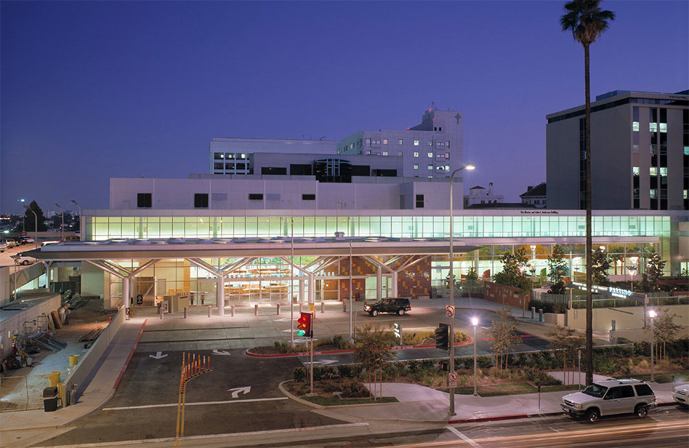 Image 6. Aerial exterior view of hospital at night showing brick clad entry lobby on left and small outdoor park on right.